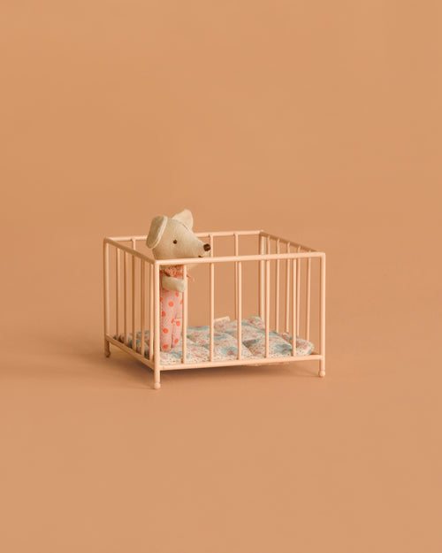 A small toy mouse in pink pajamas stands inside the Maileg Playpen, My - Rose, with a blue-patterned blanket, set against a plain beige background.