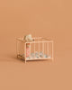 A small toy mouse in pink pajamas stands inside the Maileg Playpen, My - Rose, with a blue-patterned blanket, set against a plain beige background.