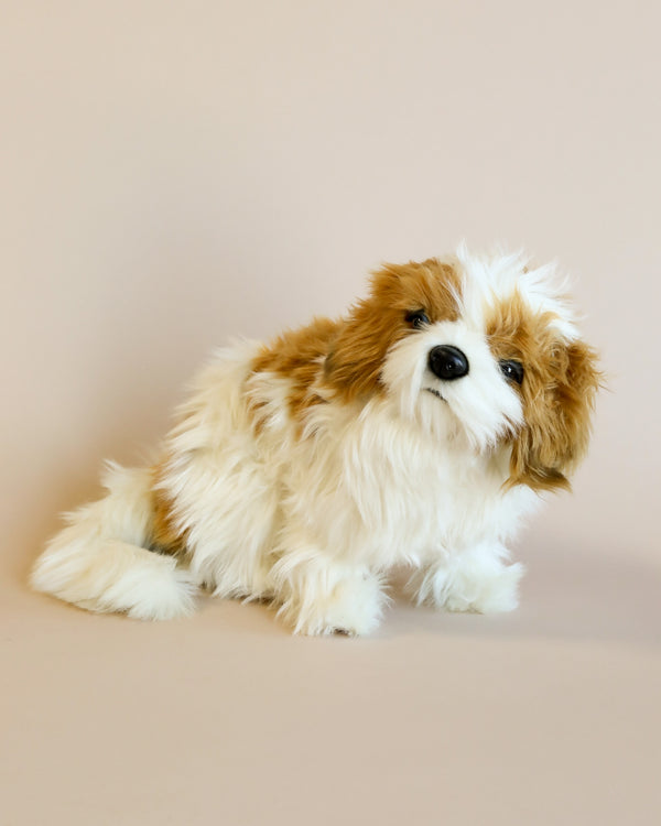 A fluffy, Shih Tzu stuffed animal with realistic eyes and shaggy fur, crafted from high-quality man-made materials, sits against a plain, light beige background.