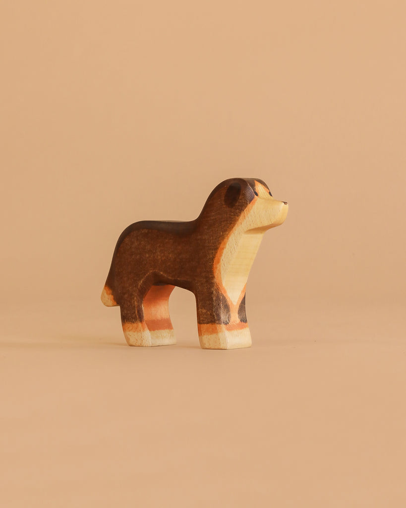 The Handmade Holzwald Bernese Mountain Dog is a small wooden figurine featuring brown, black, and beige painted details—ideal for imaginative play and a delightful addition to any sustainable toy collection.