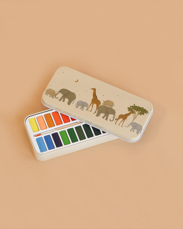 The Konges Sloejd Water Colors Paint Set - Safari is a rectangular tin box with a beige lid showing elephants, giraffes, and a tree. Inside are two rows of vibrant rectangular paint pans.