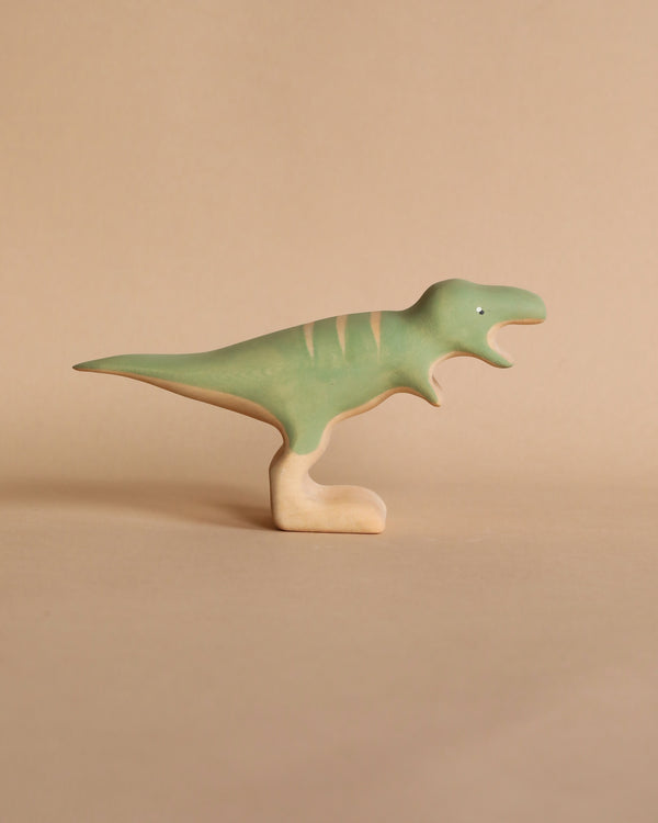 A Handmade Wooden T-rex Dinosaur toy with an ombre paint design from green to beige, standing upright.