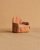 A small, plush pink armchair sits on a beige surface against a beige background. The chair features a soft texture and a low back with gold trim at the base—perfect for relaxing your Maileg Winter Chalet Set mice after an adventurous day in the snow.