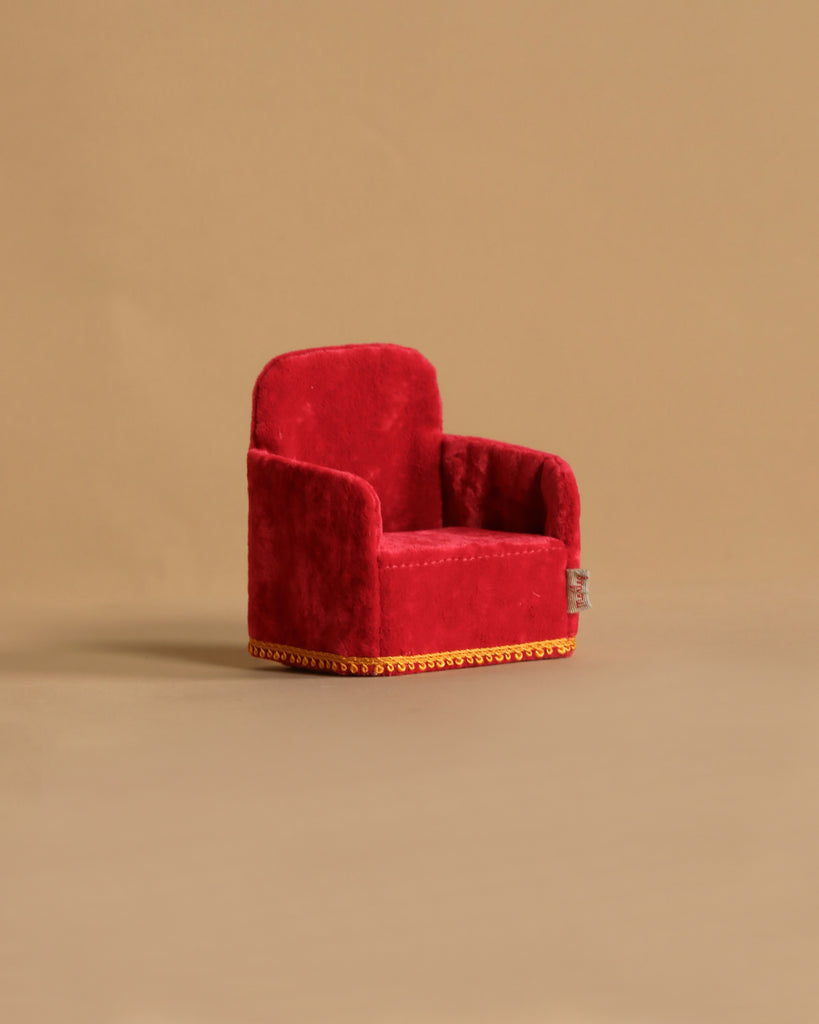 The Maileg Royal Tea Time Set, featuring a small red velvet armchair with gold trim—ideal for a Maileg King or Queen Mouse—is displayed on a plain beige background.