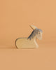 A handmade wooden donkey figurine from the Ostheimer Wooden Farm Animals Set, featuring a minimalist design with gray mane and ears, crafted from sustainably sourced wood, shown on a light orange background.