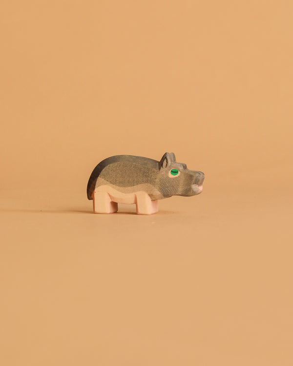 The Ostheimer Hippopotamus - Small is a handcrafted wooden figurine with painted details, shown on a light brown background—ideal for imaginative play.