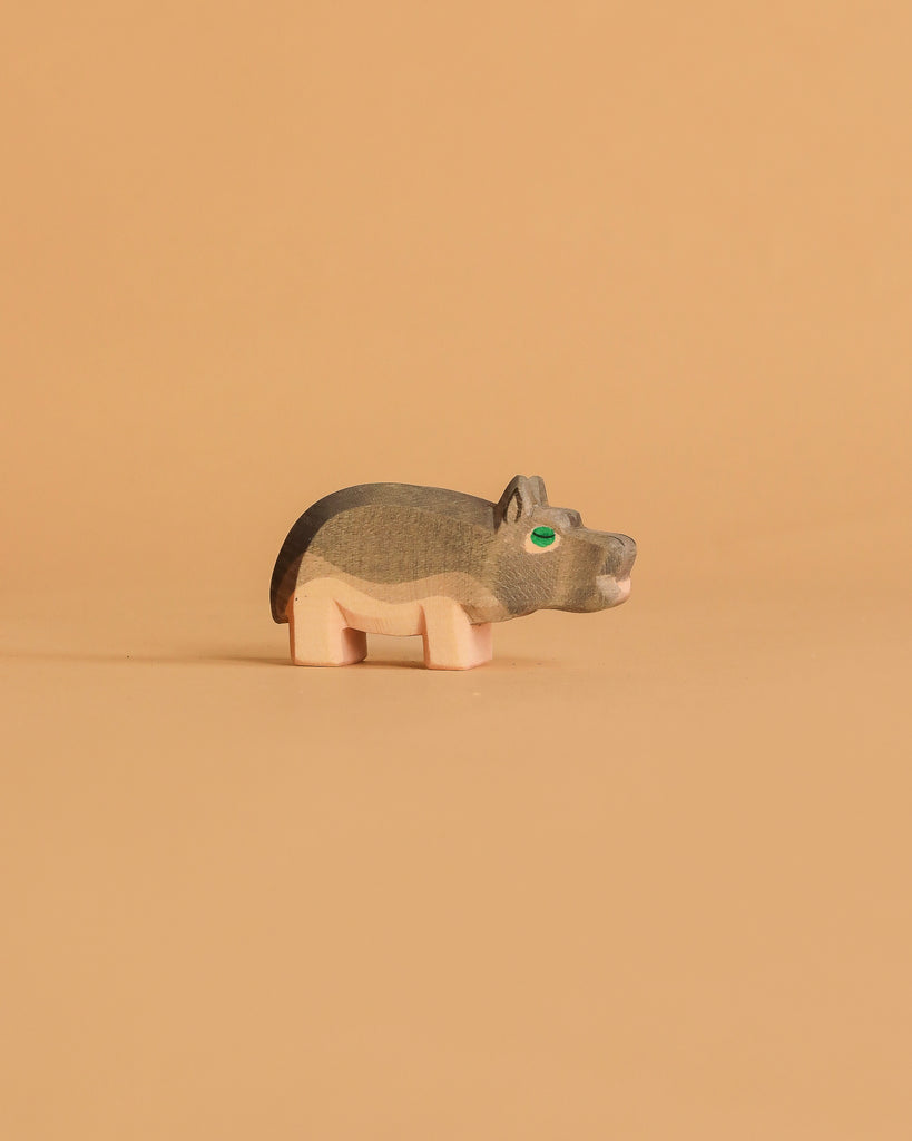 The Ostheimer Hippopotamus - Small is a handcrafted wooden figurine with painted details, shown on a light brown background—ideal for imaginative play.