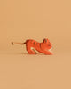 An Ostheimer Handmade Wooden Safari Animals Set tiger, small and hand-painted with a rope tail, is displayed against a plain light brown background, highlighting the charm of handcrafted toys.