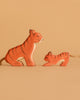 The Ostheimer Handmade Wooden Tiger Set features two painted wooden tiger figurines, one large and one small, with black stripes and rope tails, displayed side by side on a beige background—perfect sustainable toys.