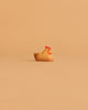 A handcrafted wooden chicken from the Ostheimer Handmade Wooden Farm Animals Set, featuring a red comb, sits on a beige surface—made from sustainably sourced materials in classic Ostheimer style.