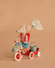 The Maileg Big Sister Gone Fishing Set features a tricycle mouse in a red shirt and blue skirt riding a red tricycle with a white basket holding a toy fish, plus a green bucket and net—all set against a plain beige background.