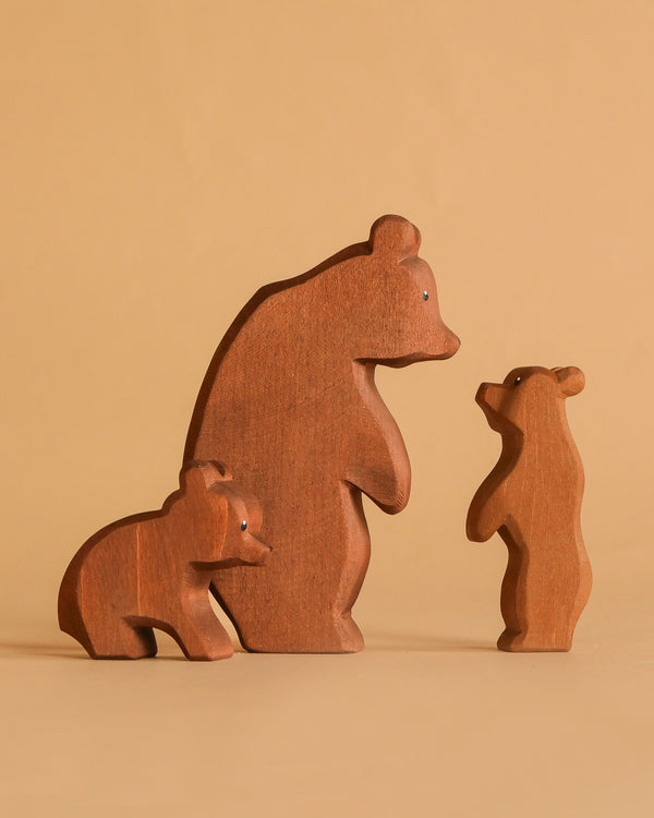 The Ostheimer Handmade Wooden Bear Set features one large and two small handcrafted bears, arranged on a beige background to resemble a bear family. Made from sustainably sourced wood, this set celebrates timeless, simple design.