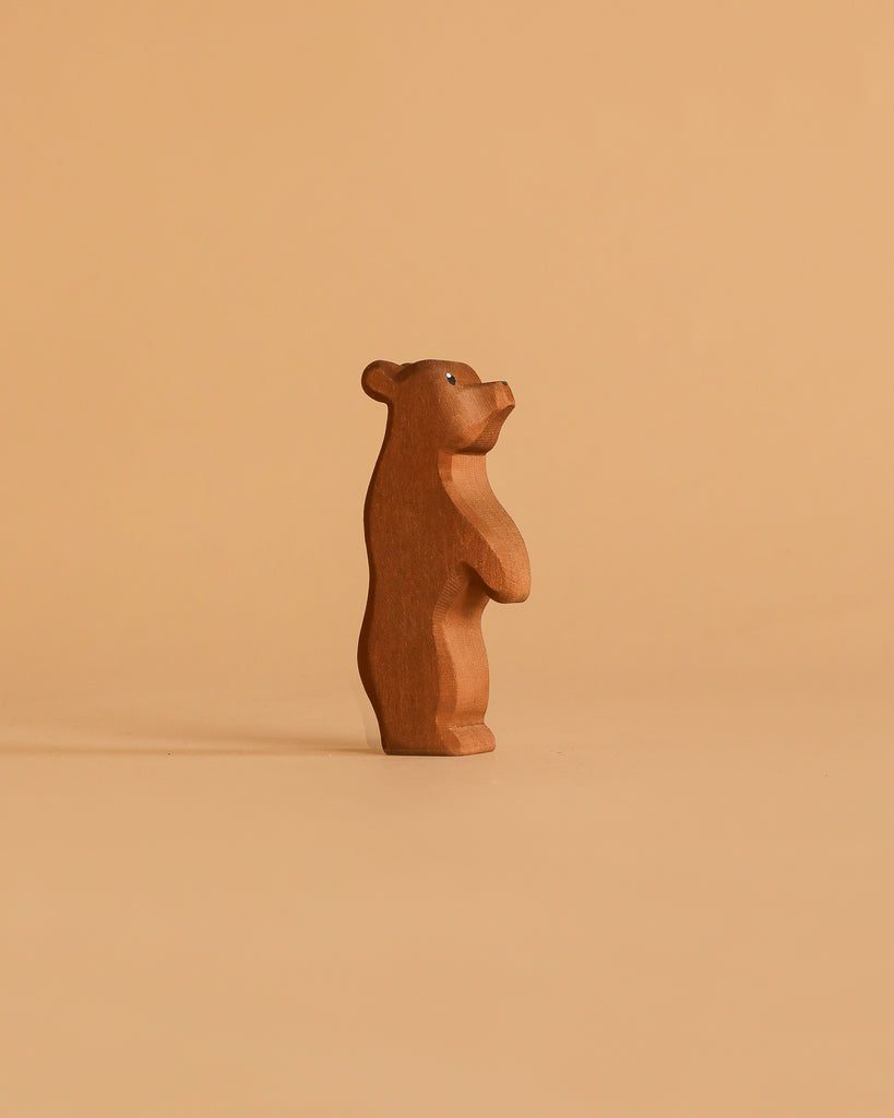 The Ostheimer Handmade Wooden Bear Set features a small, handcrafted wooden bear figurine standing upright on a plain beige background. The simple, stylized design is reminiscent of classic Ostheimer toys with minimal details and timeless charm.