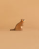 An adorable raccoon from the Ostheimer Handmade Wooden Woodland Animals Set sits upright on a beige background, its minimalist design and sustainable craftsmanship beautifully highlighted.