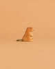 The Ostheimer Beaver - Sitting figurine, featuring a gray tail, rests against a light orange background—a charming handcrafted wooden toy ideal for imaginative play.