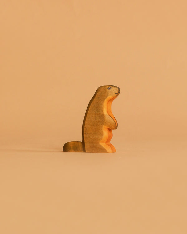 The Handmade Holzwald Marmot, a small wooden figurine, stands upright against a plain light brown background—an adorable and eco-friendly addition to any sustainable toy collection.