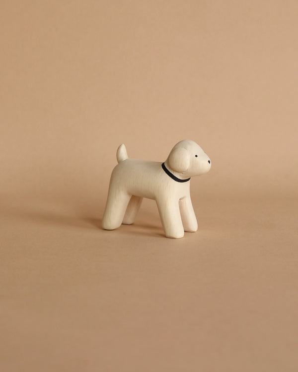 A small, handcrafted figurine of a Poodle with a simple design crafted from Albizia wood, featuring a dark collar, standing against a plain, light beige background.