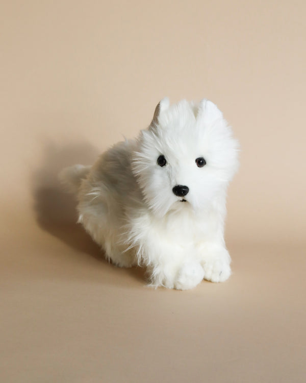A realistic West Highland White Terrier stuffed animal with fluffy fur, black eyes, and a cute expression, sitting against a plain beige background.