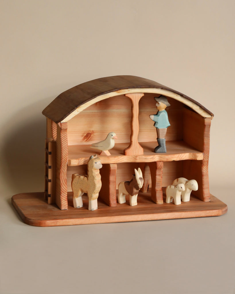 Handmade Wooden Barn featuring a farmer, animals like sheep, a horse, a llama, and a bird, displayed on two levels within an arched structure against a neutral background. This solid wood barn