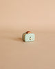 A small, light blue toy toaster with brown toast, ideal for the Maileg Fully Furnished SuitCasa kitchen or mouse home, displayed on a plain beige background.
