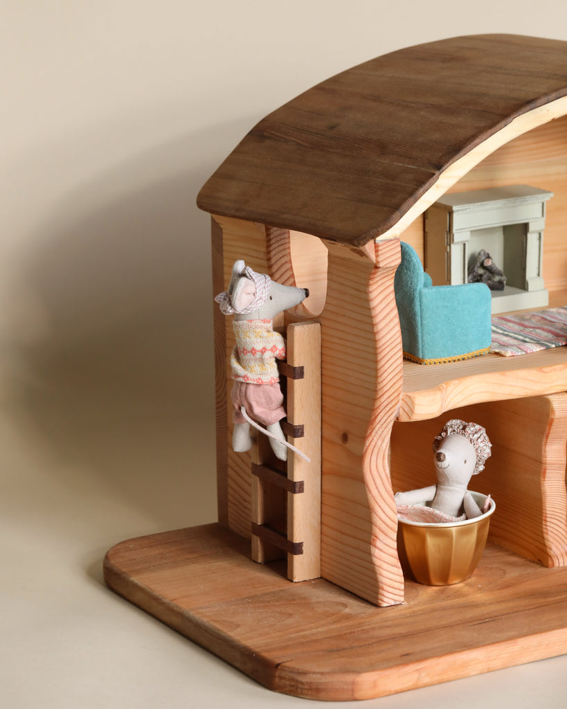 A [Handmade Wooden Barn] with a mouse climbing a ladder outside and another mouse inside in a bathtub. The [Handmade Wooden Barn] features detailed furnishings including a bed and bathtub, ideal for imaginative play.