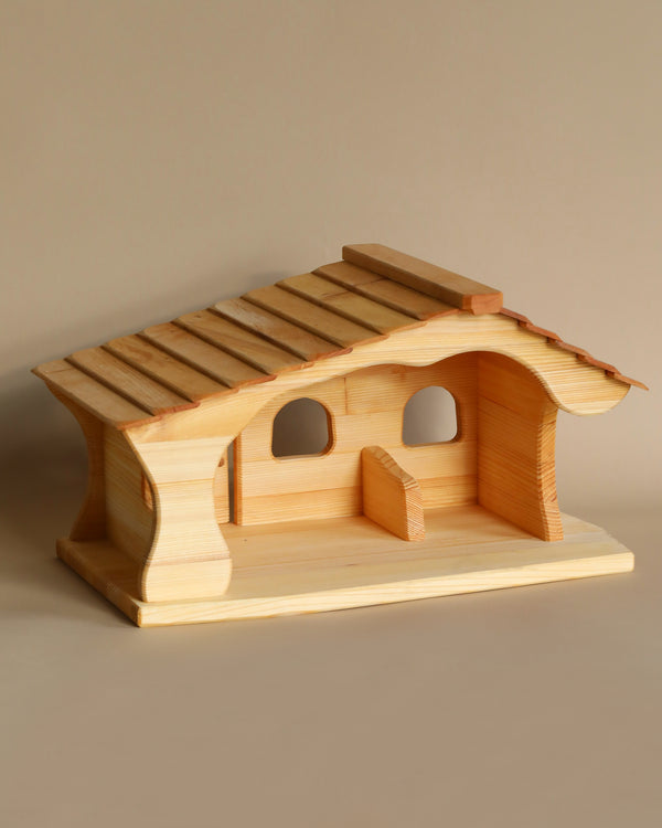 A handcrafted Ostheimer Stable Barn with a slanted roof and two circular windows, displayed on a neutral background.