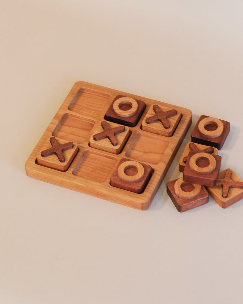 A Wooden Tic-Tac-Toe Game - Made in USA with xs and os placed on a beige background. Some pieces are inside the board slots while others are beside the board.