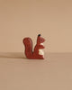 The Holztiger Squirrel, brown is a small handcrafted figurine made from maple and beech wood, featuring a white chest patch and shown standing upright against a plain beige background.
