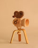The Father’s Factory | Super 16 Pro Wooden Toy Camera with Tripod features a heart-shaped handle and three-legged stand, perfect for storytelling and pretend play—all showcased against a beige background.