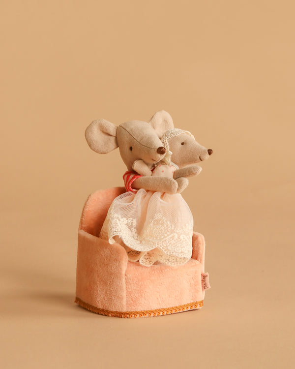 The Maileg Big Sister and Me Set features two plush mice in lace outfits sitting together in a cozy, peach-colored soft folding chair against a plain beige background.