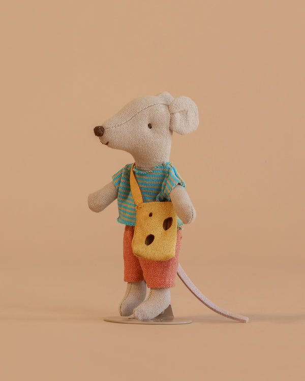 The Maileg Little Brother Mouse with Bag toy stands upright, dressed in a blue striped shirt and red shorts, and carries a yellow Swiss cheese-shaped shoulder bag against a plain beige background.