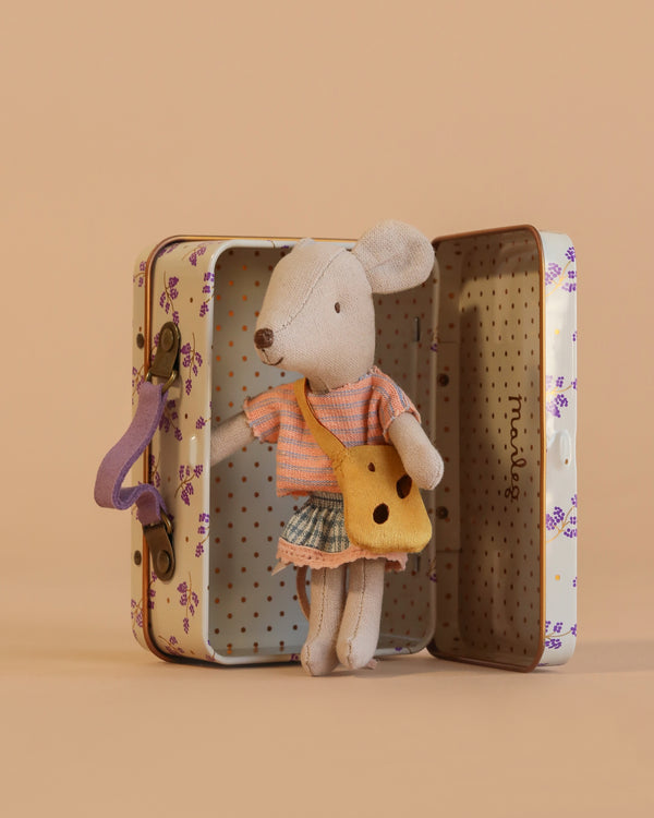 The Maileg Little Sister On the Go Suitcase Set features a mouse in a striped shirt, plaid skirt, and yellow bag next to an open floral suitcase with a polka dot interior. Contains small parts; not suitable for young children.
