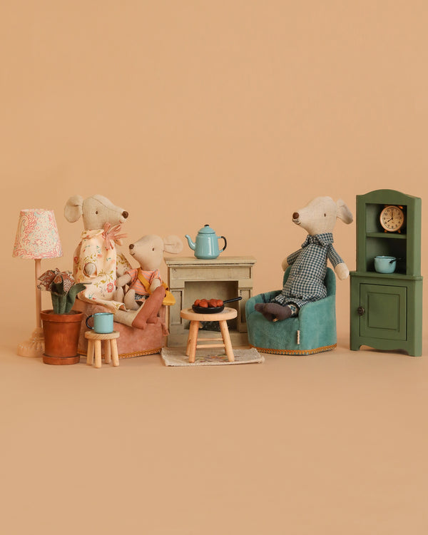 The Maileg Grandparents Set features three mice seated around a small table with a teapot and snacks in a cozy, dollhouse-style room, surrounded by Maileg accessories like a lamp, green cabinet, and soft neutral décor.