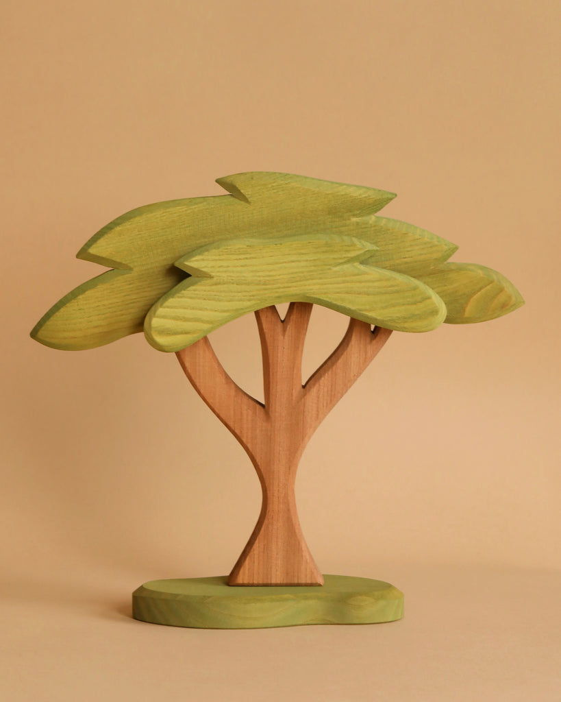 An Ostheimer African Tree, handcrafted from wood and featuring a green leafy stem, reminiscent of Ostheimer's exquisite wooden toys.