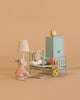 Two Maileg mice from the Little Brother and Sister Bedroom Set create a cozy scene: one sits by a vintage bed as the other is tucked in. The Maileg room also features a lamp, rug, wardrobe, and clock for added charm.