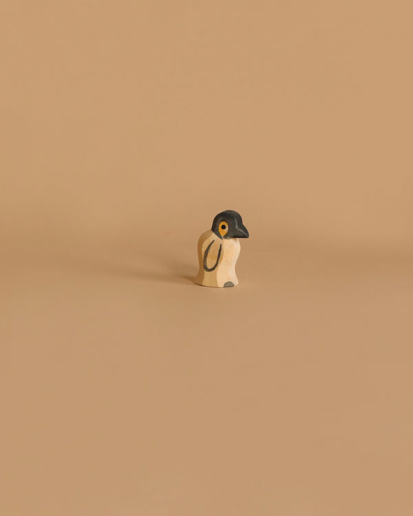 The Ostheimer Penguin, Small is a minimalist wooden figurine featuring a black head and white body. This handcrafted toy stands alone against a beige background, characterized by its simplicity and modern aesthetic. With minimal details, it offers a clean design that’s perfect for imaginative play.