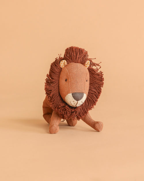 Maileg Little Leo the Lion, a small plush toy with a brown mane and beige face, sits on a matching background facing forward—a charming companion for all ages who love soft animals.