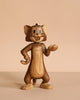 The Boyhood Tom & Jerry X Tom, Small is a solid oak figurine of Tom the cat, smiling with one hand on his hip and the other paw raised, displayed against a beige background.