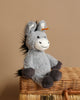 Presenting the Steiff Dinkie Donkey Plush Stuffed Toy: an 8-inch soft, gray donkey with darker gray hooves. Adorned with black hair on its head and a stitched, smiling face, it also features the iconic Button in Ear attached to a yellow and red tag. The background is plain white.