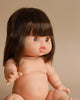 Introducing the Minikane Baby Doll (13") - Jeanne, a realistic and anatomically correct baby doll with fair skin, blue eyes, and short brown hair with bangs. Jeanne exudes a delightful natural vanilla scent and is seated with her legs spread and arms reaching forward. Note: Clothing is sold separately.