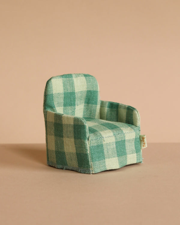 The Maileg Folding Chair, Mouse - Green Checker, sits on a beige surface with a plain beige background—ideal for the Mouse hole Farmhouse.