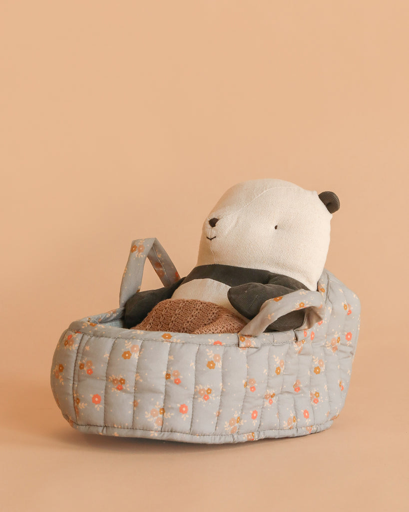 The Maileg Panda Bear in Carry Cot, featuring floral accents, is displayed against a plain beige background.