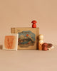 The Hello Autumn Set (Grapat X Ostheimer Limited Edition) features a "AUTUMN!" box with a mountain scene and leaf painting, plus exclusive wooden figurines—a person, mushrooms, and hedgehog—arranged on a beige background.