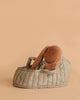 The Maileg Sleeping Bunny in Carry Cot features a cozy plush bunny tucked inside a floral-patterned carry cot, all set against a plain beige background.