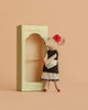 The Maileg Beautician Mouse, Mum wears a black dress, white apron, red shoes, and a red flower in its ear, standing beside a decorative green "Beautician" box on a soft beige background.