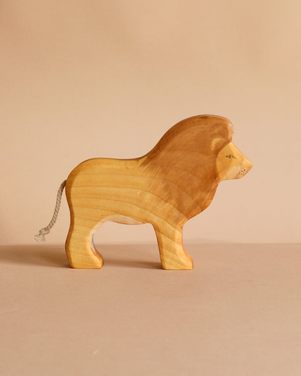 The Handmade Wooden Lion features a simple, smooth design with a rope tail and natural wood grain, displayed on a neutral beige background.