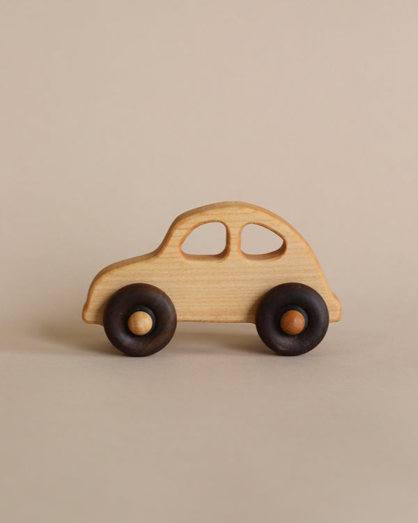 A simple Wooden 1930s Car made from FSC certified wood, with a natural beeswax finish and dark wheels, positioned on a light beige background.