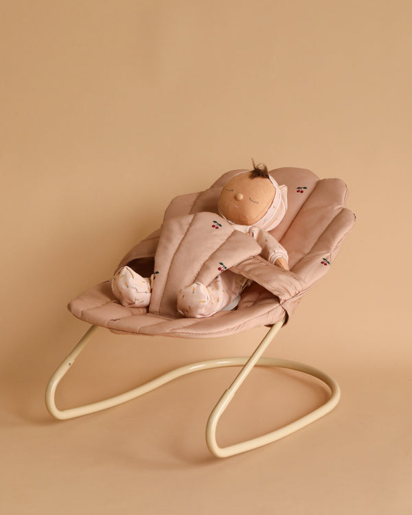 Doll toy in a bouncer toy with cherry print