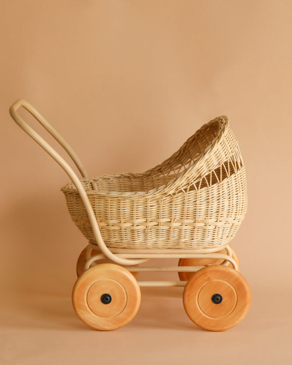 A vintage Rattan Doll Pram Stroller with large wooden wheels, displayed against a plain beige background.
