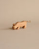 A handcrafted Ostheimer Lion toy resembling a stylized lion with a tail made from twine, positioned against a plain beige background. The lion is mid-stride, with simple features and carved details.